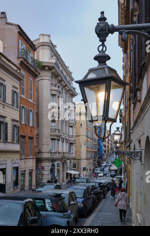 Charmante Straßenszene in Rom, Italien, mit Vintage-Laternen, die eine klassische italienische Straße beleuchten. Das Wesen des Alltags einfangen Stockfoto