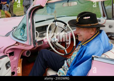 Stolzer Besitzer sitzt auf dem Fahrersitz einer Cadillac Parade, die Pink Lady - John Gollop Stockfoto