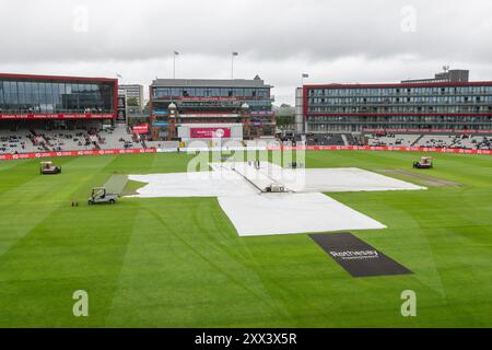 Regenbezüge werden entfernt, wenn der Regen vor dem 1. Rothesay Test Match Day 2 in Old Trafford, Manchester, Großbritannien, 22. August 2024 stoppt (Foto: Craig Thomas/News Images) Stockfoto