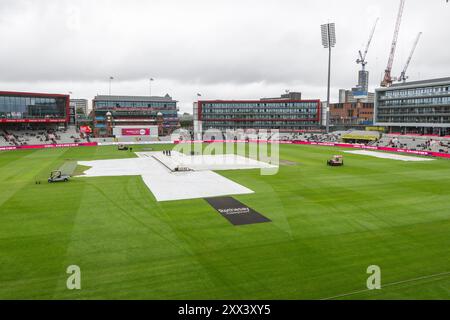 Die Regenbedeckung wird entfernt, wenn der Regen vor dem 1. Rothesay Test Match Day 2 in Old Trafford, Manchester, Großbritannien, 22. August 2024 (Foto: Craig Thomas/News Images) in, am 22. August 2024. (Foto: Craig Thomas/News Images/SIPA USA) Credit: SIPA USA/Alamy Live News Stockfoto