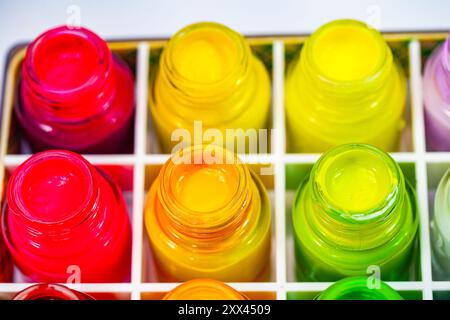 Ein lebendiges Display mit verschiedenfarbigen Tintenflaschen, die in einem Rastermuster angeordnet sind und ein Spektrum von hellen und lebendigen Farbtönen darstellen. Das Bild hebt den hervor Stockfoto