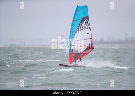 Beachlands, Hayling Island. August 2024. Starke Winde und zeitweilige Regenfälle für die Südküste heute, als Ex-Hurrikan Ernesto an Land kam. Windsurfer genießen die anspruchsvollen Bedingungen auf Beachlands, Hayling Island in Hampshire. Quelle: james jagger/Alamy Live News Stockfoto