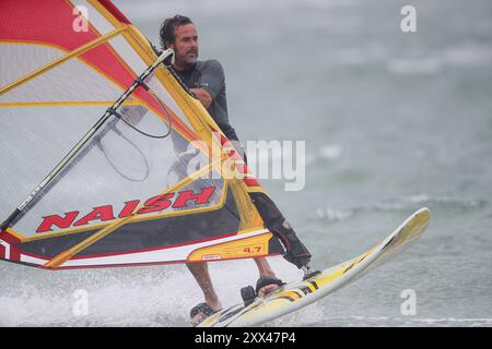 Beachlands, Hayling Island. August 2024. Starke Winde und zeitweilige Regenfälle für die Südküste heute, als Ex-Hurrikan Ernesto an Land kam. Windsurfer genießen die anspruchsvollen Bedingungen auf Beachlands, Hayling Island in Hampshire. Quelle: james jagger/Alamy Live News Stockfoto