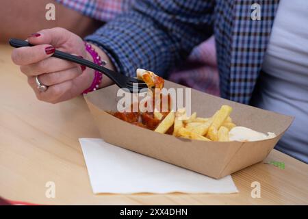 Person ist Currywurst mit Pommes Frites rot weiß, allgemein, Feature, Randmotiv, Symbolfoto Saskia ESKEN, SPD-Bundesvorsitzende Sarah PHILIPP, SPD Landesvorsitzende NRW, Serdar YUEKSEL, SPD, MDL, besuchen Sie eine Fluechtlingsunterkunft der AWO in Bochum, 21.08.2024. *** Person isst Currywurst mit Pommes frites rot weiß, allgemein, Feature, Grenzmotiv, Symbolfoto Saskia ESKEN, SPD-Bundesvorsitzende Sarah PHILIPP, SPD-Landesvorsitzende NRW, Serdar YUEKSEL, SPD, MDL, Besuch in einem Flüchtlingsheim der AWO in Bochum, 21 08 2024 Stockfoto