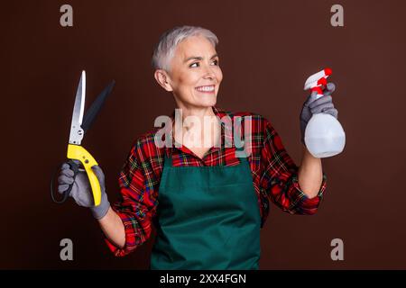 Foto der schönen hübschen Frau Dekoratorin Designer tragen rot kariertes Hemd Look leerer Raum isoliert auf braunem Hintergrund Stockfoto