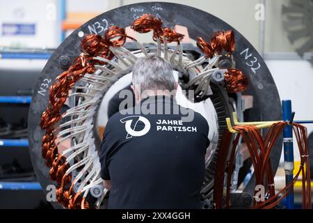 22. August 2024, Sachsen, Döbeln: Ein Mitarbeiter der Partzsch-Gruppe arbeitet an einem Stator für Elektromotoren und Generatoren in einer Produktionshalle. Das Unternehmen feiert sein 70-jähriges Bestehen am 22. August 2024. Foto: Sebastian Kahnert/dpa Stockfoto