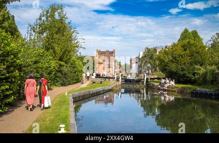 Die Leute laufen in der Nähe des Newbury Lock am Kennet und Avon Canal, mit Bridge Street in der Ferne, Newbury, Berkshire, Großbritannien. Stockfoto