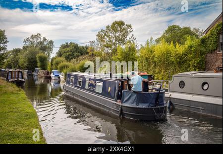 Ein Mann steuert ein Urlaubskanalboot in der Nähe des Newbury Lock auf dem Kennet and Avon Canal in Newbury, Berkshire, England, Großbritannien Stockfoto