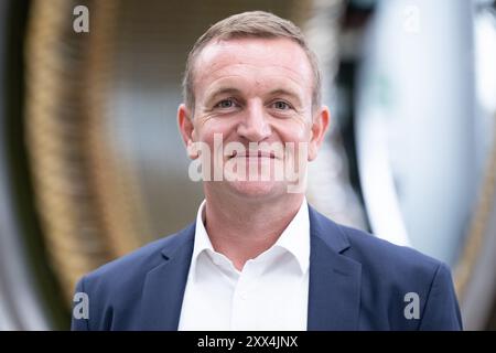 22. August 2024, Sachsen, Döbeln: Christian Partzsch, Geschäftsführer der Partzsch Elektromaschinenbau GmbH, steht in einer Produktionshalle vor einem Windkraftstator für Windräder. Das Unternehmen feiert sein 70-jähriges Bestehen am 22. August 2024. Foto: Sebastian Kahnert/dpa Stockfoto