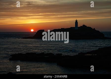 Sonnenuntergang über dem Godrevy Lighthouse von der Klippe nahe der Gwithian Küste, Cornwall, Großbritannien Stockfoto