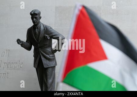 London, Großbritannien. August 2024. In der Nähe der Statue des Schriftstellers George Orwell vom britischen Bildhauer Martin Jennings weht eine palästinensische Flagge, während palästinensische Unterstützer vor dem Hauptquartier der BBC im Broadcasting House gegen die "voreingenommene" Berichterstattung der öffentlich-rechtlichen Rundfunkanstalten über Israels Krieg gegen Gaza protestieren, der sich jetzt im zehnten Monat befindet. Quelle: Ron Fassbender/Alamy Live News Stockfoto