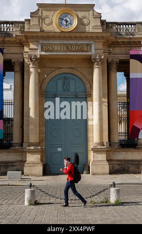 Mann mit Musikinstrument, der am hinteren Eingang der französischen Nationalversammlung in Paris vorbeigeht. Stockfoto