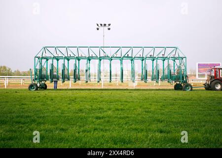 Leere Pferderennen, die auf Reiter warten. Grün gefärbtes Startfeld beim Start mit der Traktormaschine am hippodrom des Pferdes. E Stockfoto