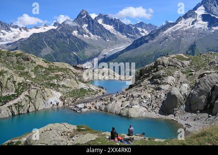 Sommerwandern in der Nähe des Lac Blanc im Naturschutzgebiet Aiguilles Rouge oberhalb von Chamonix, Frankreich. Gipfel des Mont Blanc-Massivs im Hintergrund. Stockfoto