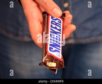 Tambow, Russische Föderation - 23. Januar 2024 Frauenhand mit Snickers Bar. Nahaufnahme Stockfoto