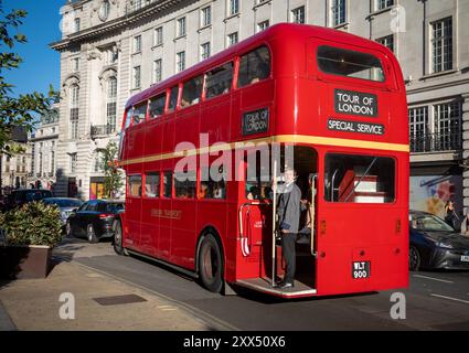 Ein traditioneller roter Routemaster London Bus mit einem Zugbegleiter, der heute für Touren durch London genutzt wird. London, England, Großbritannien Stockfoto