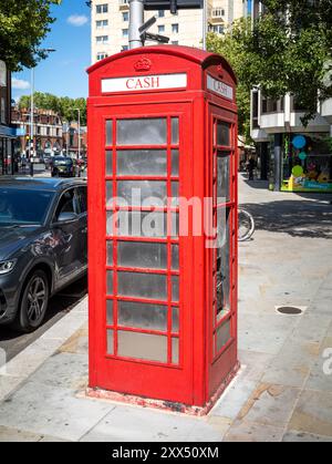 Ein traditionelles rotes öffentliches Telefonfach K6, das für einen Geldautomaten und ein öffentliches Telefon an der King's Road, Chelsea, London, eng, umfunktioniert wurde Stockfoto