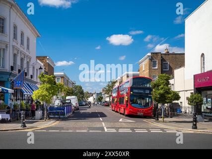 Zwei rote Londoner Doppeldeckerbusse parkten an einem sonnigen Tag in der Limerston St, einer Seitenstraße an der King's Road, Chelsea, London, England, Großbritannien Stockfoto