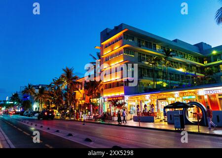 Außenansicht des Hotel Victor, Versace Mansion und beleuchtete Art déco-Gebäude und Restaurants am Ocean Drive, Miami Beach, Florida, USA Stockfoto