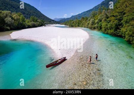 Mutter und Sohn auf einem Familienausflug mit einem roten Kanu auf dem Fluss Soca, paddeln auf einem spektakulären grünen Fluss umgeben von den julischen alpen, Tolmin, Slowenien Stockfoto