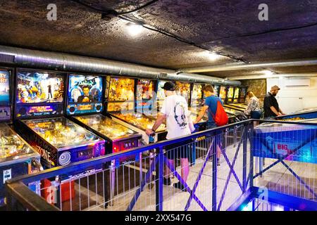 Menschen, die auf Flipperautomaten im interaktiven Museum der Pinball-Station in Warschau, Polen spielen Stockfoto