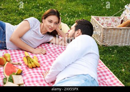 Nettes Paar, das draußen auf grünem Gras picknickt Stockfoto