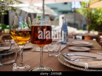 Zwei Weingläser stehen auf einem Tisch mit einer blauen Flasche Wasser Stockfoto