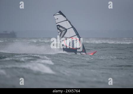 Beachlands, Hayling Island. August 2024. Starke Winde und zeitweilige Regenfälle für die Südküste heute, als Ex-Hurrikan Ernesto an Land kam. Windsurfer genießen die anspruchsvollen Bedingungen auf Beachlands, Hayling Island in Hampshire. Quelle: james jagger/Alamy Live News Stockfoto