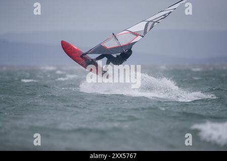 Beachlands, Hayling Island. August 2024. Starke Winde und zeitweilige Regenfälle für die Südküste heute, als Ex-Hurrikan Ernesto an Land kam. Windsurfer genießen die anspruchsvollen Bedingungen auf Beachlands, Hayling Island in Hampshire. Quelle: james jagger/Alamy Live News Stockfoto