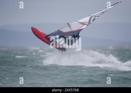 Beachlands, Hayling Island. August 2024. Starke Winde und zeitweilige Regenfälle für die Südküste heute, als Ex-Hurrikan Ernesto an Land kam. Windsurfer genießen die anspruchsvollen Bedingungen auf Beachlands, Hayling Island in Hampshire. Quelle: james jagger/Alamy Live News Stockfoto