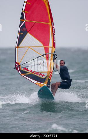 Beachlands, Hayling Island. August 2024. Starke Winde und zeitweilige Regenfälle für die Südküste heute, als Ex-Hurrikan Ernesto an Land kam. Windsurfer genießen die anspruchsvollen Bedingungen auf Beachlands, Hayling Island in Hampshire. Quelle: james jagger/Alamy Live News Stockfoto