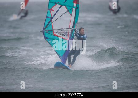 Beachlands, Hayling Island. August 2024. Starke Winde und zeitweilige Regenfälle für die Südküste heute, als Ex-Hurrikan Ernesto an Land kam. Windsurfer genießen die anspruchsvollen Bedingungen auf Beachlands, Hayling Island in Hampshire. Quelle: james jagger/Alamy Live News Stockfoto