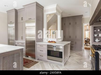 Elegante Küche mit zwei Säulen Kühlschrank und einzigartigem Eckfenster Stockfoto