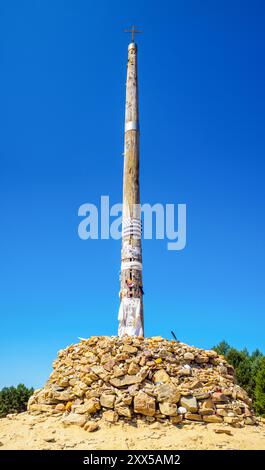 Das berühmte Cruz de Ferro, ein bedeutendes Wahrzeichen auf dem Jakobsweg in der Nähe von Foncebadon. Castilla y Leon, Spanien. Stockfoto