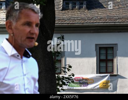 Neustadt An Der Orla, Deutschland. August 2024. An einem Haus hängt ein Banner mit der Aufschrift „Weltoffenes Thüringen“. Im Vordergrund spricht AfD-Spitzenkandidat Björn Höcke bei einer Wahlkundgebung. Am 1. September wird in Thüringen ein neuer landtag gewählt. Quelle: Hannes P. Albert/dpa/Alamy Live News Stockfoto