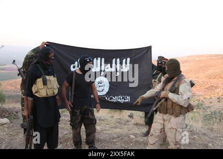 ISIS-Kämpfer halten die Al-Qaida-Flagge mit der Aufschrift "Islamischer Staat Irak und Levante" Stockfoto