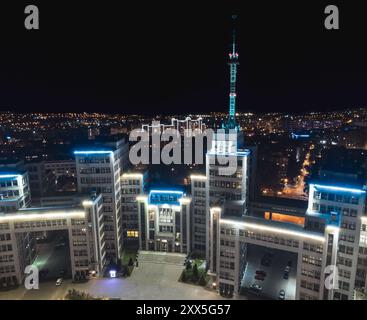 Nächtliche Luftaufnahme von Derzhprom mit blauer Beleuchtung und Antenne auf Charkiws Freiheitsplatz Stockfoto