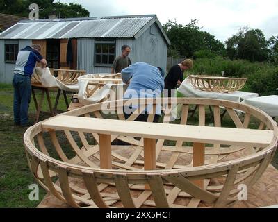 Coracle Making, Studenten in einem Workshop, um eine der ältesten Formen des Wassertransports zu fördern. Der Holzrahmen aus Esche des Bootes wird gebaut, dann Cotton cali Stockfoto