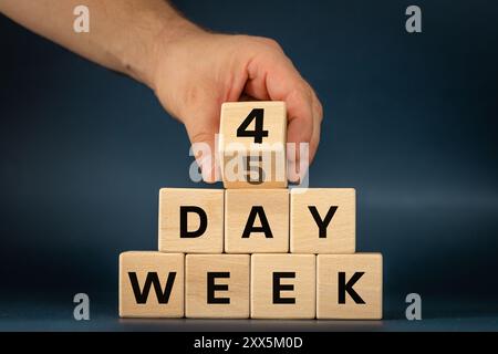 4-Tage-Woche, Geschäftskonzept. Handdrehung des Holzwürfels von 5 bis 4. Symbol für die Verkürzung der Arbeitswoche. 4 Tage Woche auf Blöcken geschrieben, wunderschönes Navy B Stockfoto