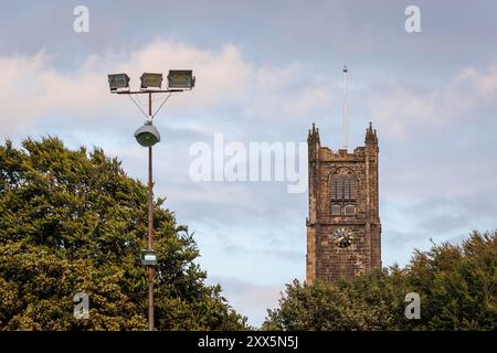 Der Turm der Lancaster Priory Church vom Fußballplatz Lancaster City aus gesehen, die Giant Axe, zeigt einen Pfosten mit Flutlichtern Stockfoto