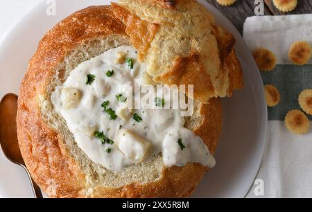 Großansicht einer Brotschüssel mit Muschelsuppe im New England Style mit Serviette und Austerncrackern. Stockfoto