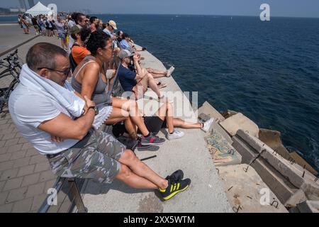 Barcelona, Spanien. August 2024. Eine große Gruppe von Menschen wartet auf dem Bootssteg auf den Start des ersten Vorlaufens des America's Cup. Die Louis Vuitton Preliminary Regatta 2024 America's Cup hat heute Morgen die ersten Vorläufe gestartet. Besucher, Touristen und Einwohner konnten das erste Rennen des Wettbewerbs kostenlos von den Aussichtspunkten an der Küste und auf großen Bildschirmen in den Fan Zones genießen. (Foto: Paco Freire/SOPA Images/SIPA USA) Credit: SIPA USA/Alamy Live News Stockfoto