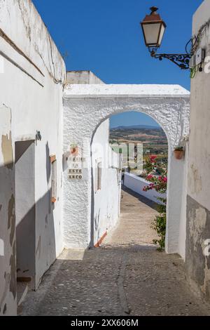 Arcos de la Frontera, Provinz Sevilla, Andalusien, Spanien. Mai 2023. Malerischer Fußweg mit einem Schild mit der Aufschrift „Kuss mich in diesem Bogen“ in Arcos de la Front Stockfoto