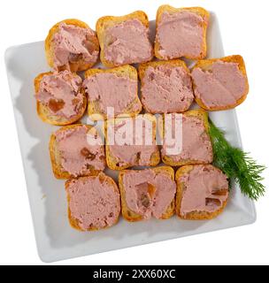 Leberpastete auf gerösteten Baguetteschnitten, garniert mit Gemüse Stockfoto