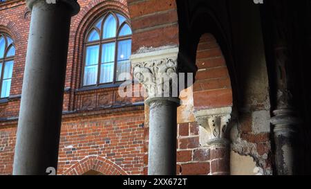 Die architektonischen Elemente des Rigaer Doms haben eine rote Backsteinfassade. Dieses bemerkenswerte Gebäude, bekannt als Rigaer Dom in Lettland, verbindet Romanesqu Stockfoto