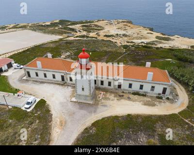 Luftaufnahme eines Leuchtturms und einer Reihe von Gebäuden entlang der Küstenlandschaft, Farol do Cabo Sardao, Sardao, Ponta do Cavaleiro, Odemira, Alentejo, Stockfoto