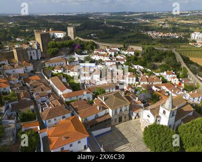 Aus der Vogelperspektive auf eine historische Stadt mit roten Dächern und einer Kirche, umgeben von Burgmauern und eingebettet in grüne Landschaft, Stadt, Burg, Castelo de Obid Stockfoto