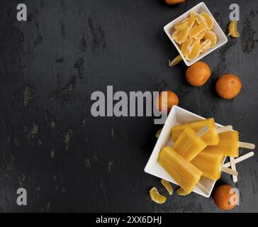 Schiefer Tafel mit hausgemachten Tangerine Eis am Stiel (selektive Fokus) als detaillierte Nahaufnahme Stockfoto