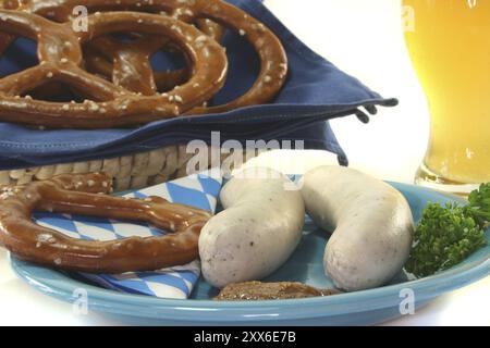 Weißwurst mit süßem Senf und Brezeln vor weißem Hintergrund Stockfoto