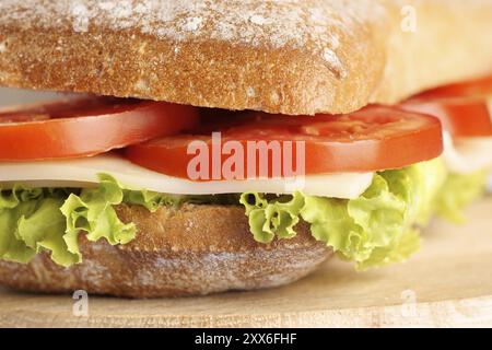 Nahaufnahme eines italienischen Panino (Sandwiches) mit frisch gebackenem Ciabatta-Brot, Salat, Käse und Tomaten. Extrem flacher Freiheitsgrad, selektiver Fokus Stockfoto